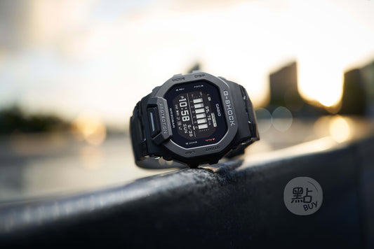 CASIO GBD-200-1DR G-Squad GBD-200 系列手錶 - 手錶置於戶外日出場景,金屬欄杆時尚生活照
