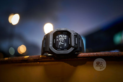 CASIO GBD-200-1DR G-Squad GBD-200 系列手錶 - 手錶夜景照，背景為城市燈光散景時尚生活照